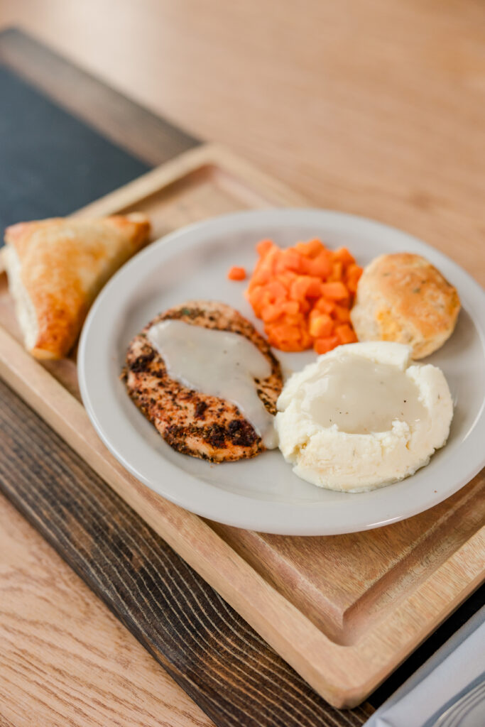 A Plate of Chicken with Mashed Potatoes, Carrots, Roll and a Pastry | Pelican Valley Senior Living